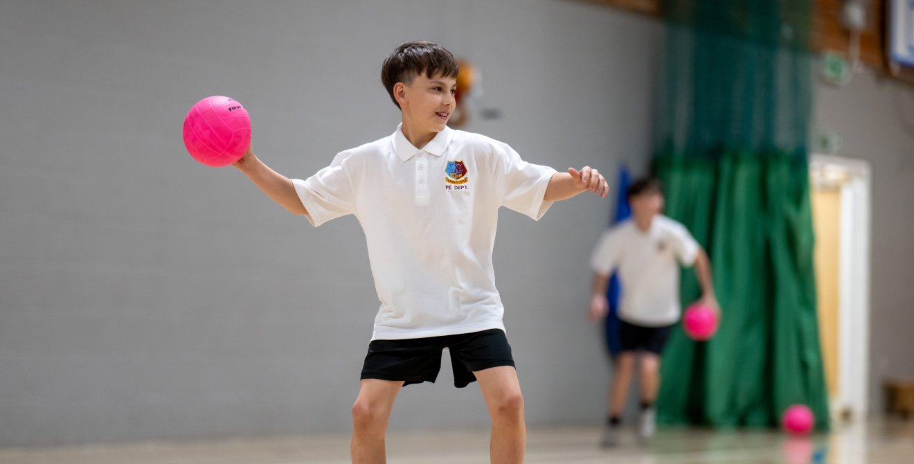 Disgybl Ysgol Gyfun Heolddu yn chwarae dodgeball.