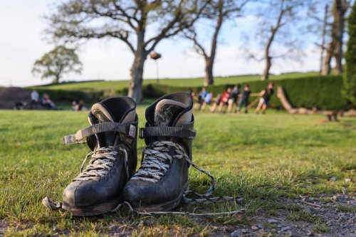 A pair of dark boots on a muddy field