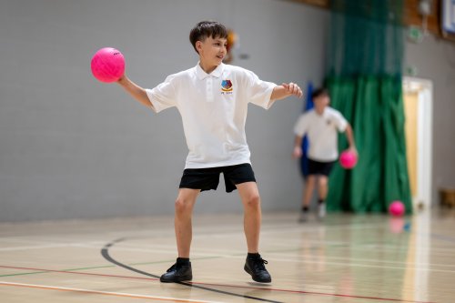 Disgybl Ysgol Gyfun Heolddu yn chwarae dodgeball.