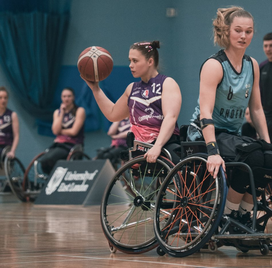 Anastasia playing wheelchair basketball in a sports hall