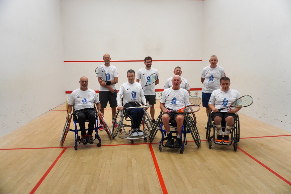 Wheelchair squash participants on a squash court.