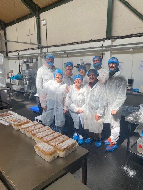 The catering team stand behind their cakes.