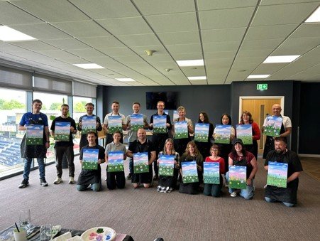 Staff hold up their art.