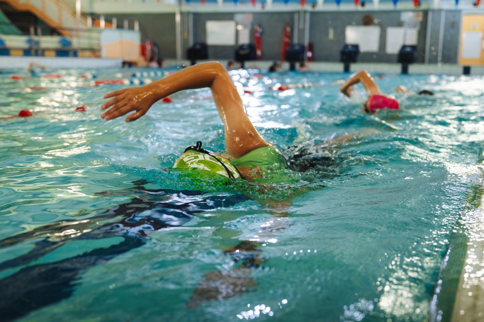 Swimmer doing breaststroke in a pool lane.